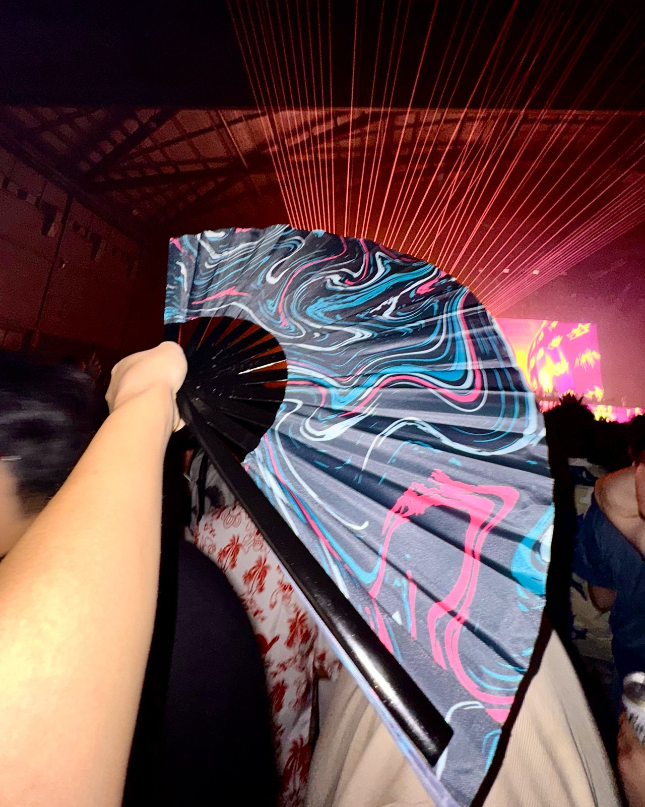 Electric Eden's reflective hand fan showcasing UV glow under blacklight